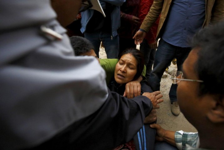 Woman cries as her son was trapped inside a collapsed house after an earthquake hit, in Kathmandu
