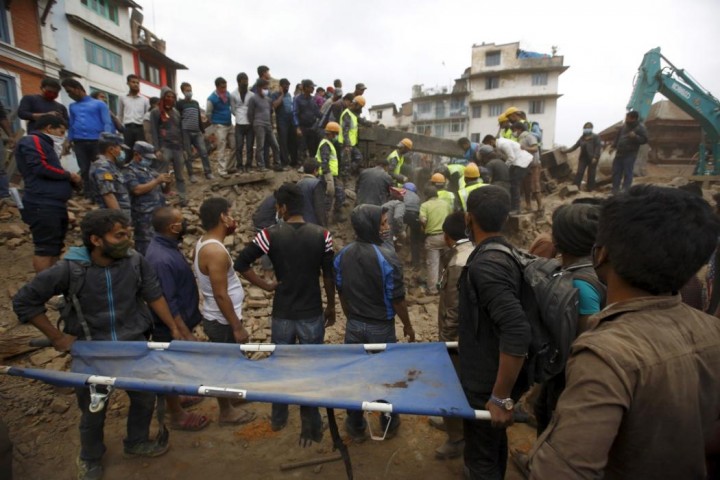 Rescue workers search for bodies as a stretcher is kept ready after an earthquake hit, in Kathmandu